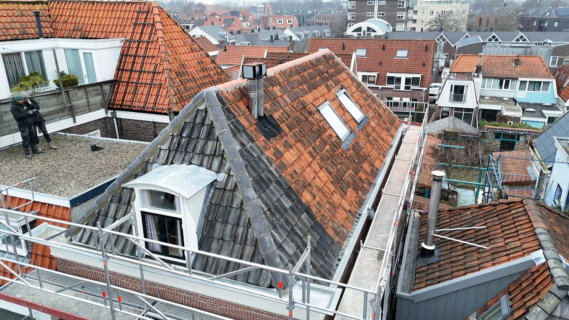 Luchtfoto van pannendaken met steigers tijdens dakrenovatie in Noord-Holland