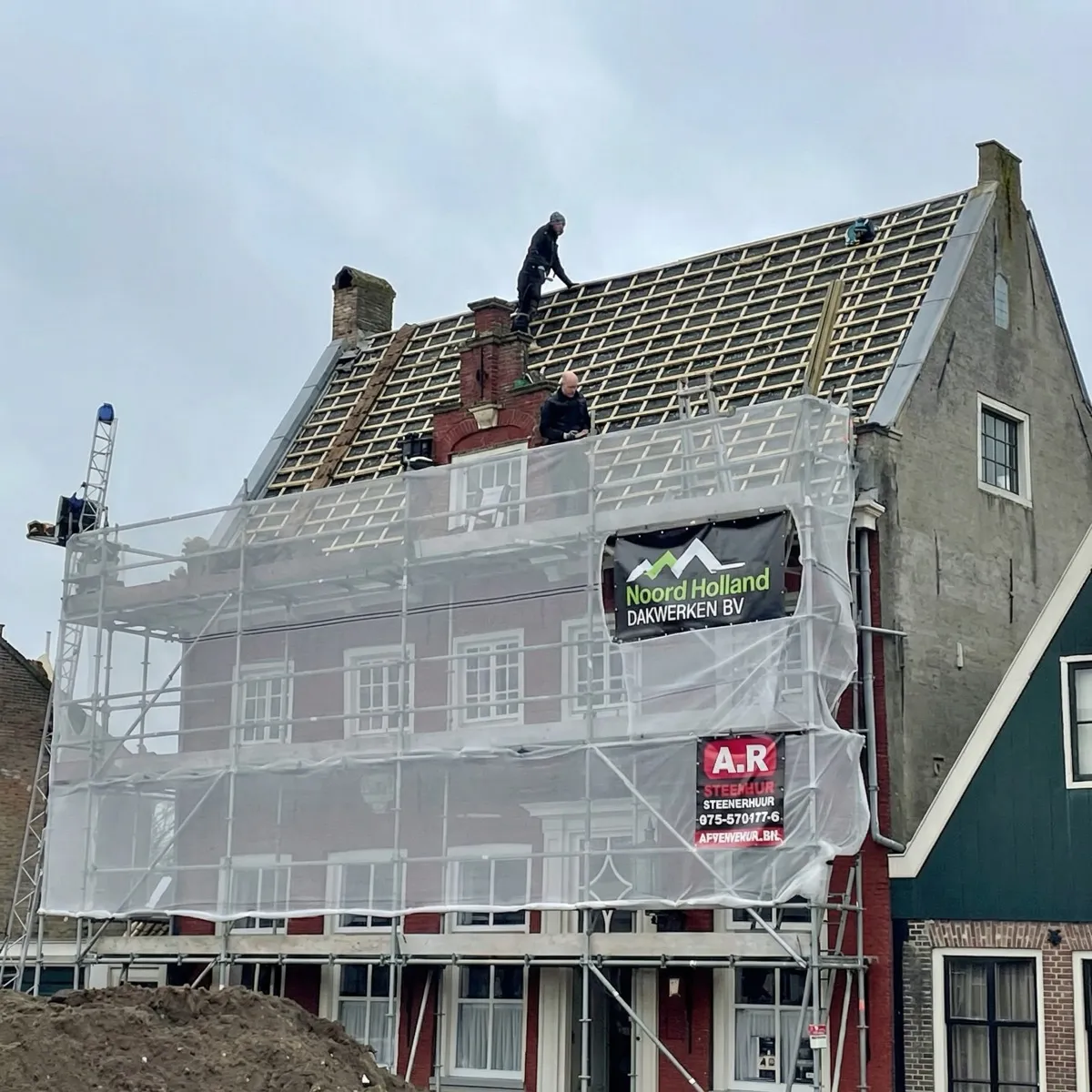 Grootschalige dakrenovatie met steigers en zichtbare daklatten op een historisch pand in Hilversum