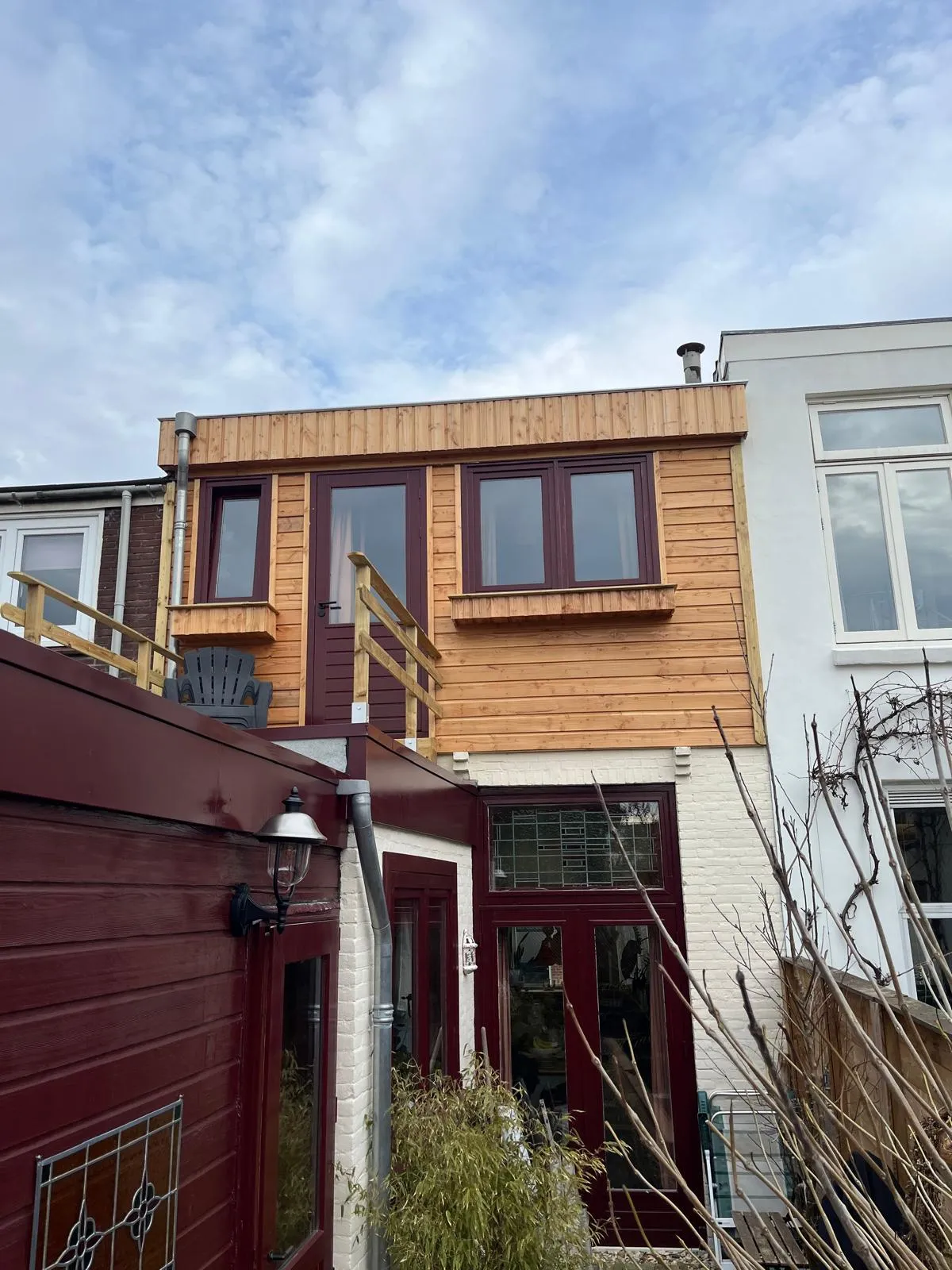 Houten dakopbouw met cederhouten gevelbekleding en grote ramen op een woning in Haarlem