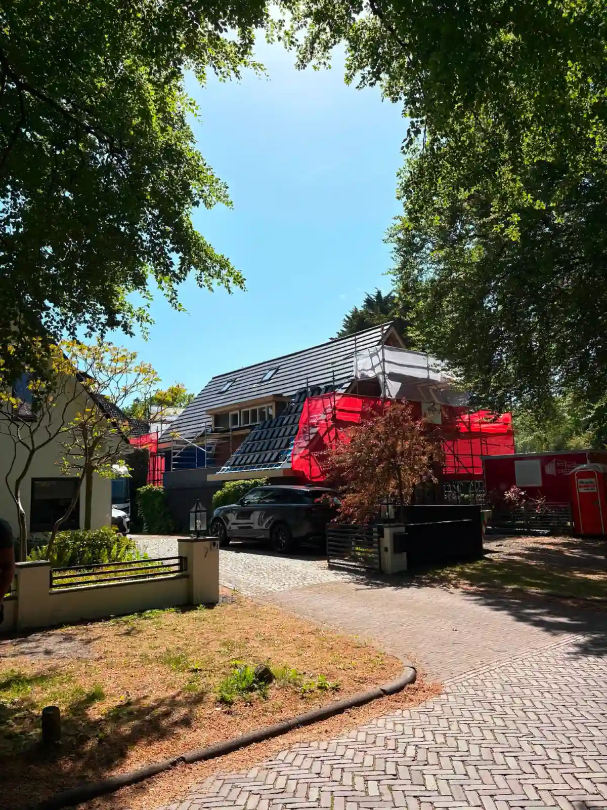 Pannendak renovatie in Bergen met zwarte Monier Tuile vlakke dakpannen en een steiger rondom de woning door NH Dakwerken